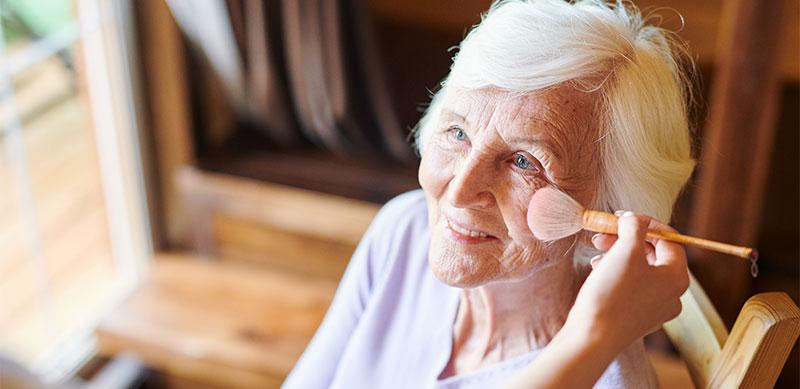 older lady looking up while blush makeup is applied