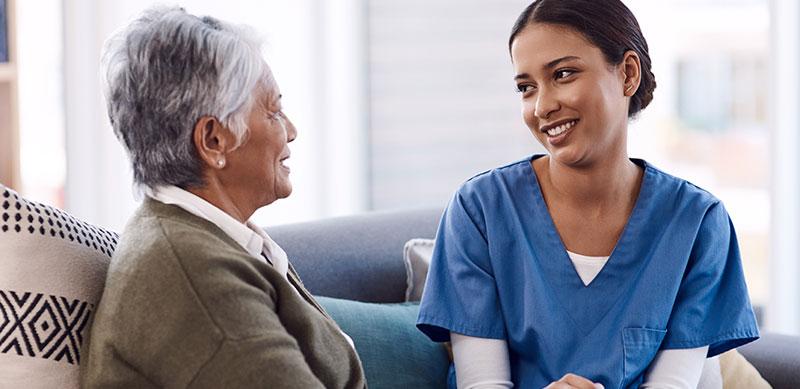 Carer sitting on couch with older lady